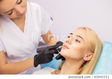 Lip Augmentation In Cosmetology Clinic. Beautiful Woman Getting Beauty Injection For Lips 65643151
