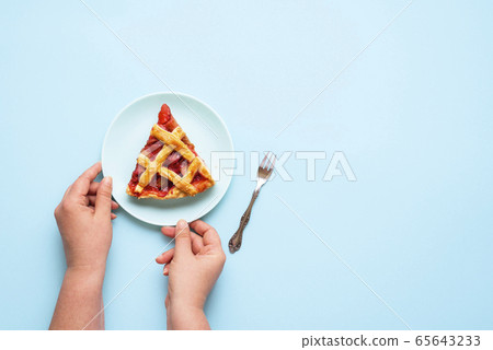 Rhubarb and strawberry pie slice. Woman hands 65643233