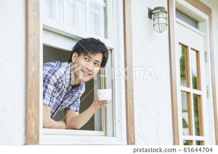 通過窗口顯示他的臉一個年輕男人的肖像 65644704