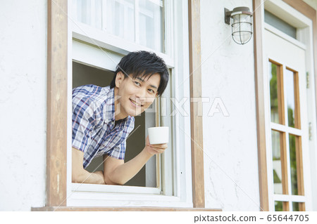 通過窗口顯示他的臉一個年輕男人的肖像 65644705