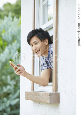 通過窗口顯示他的臉一個年輕男人的肖像 通過窗口顯示他的臉一個年輕男人的肖像 65644708