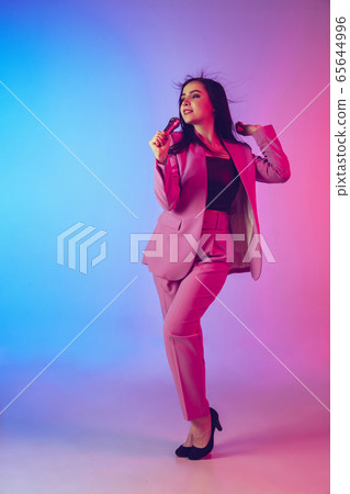 Caucasian female singer portrait isolated on gradient studio background in neon light Caucasian female singer portrait isolated on gradient studio background in neon light 65644996