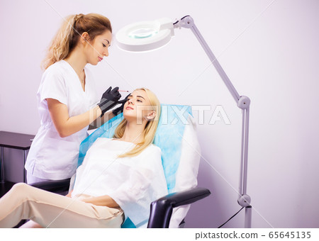 Lip Augmentation In Cosmetology Clinic. Beautiful Woman Getting Beauty Injection For Lips 65645135
