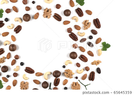 A pattern of nuts on a white background, decorated with green leaves. 65645359