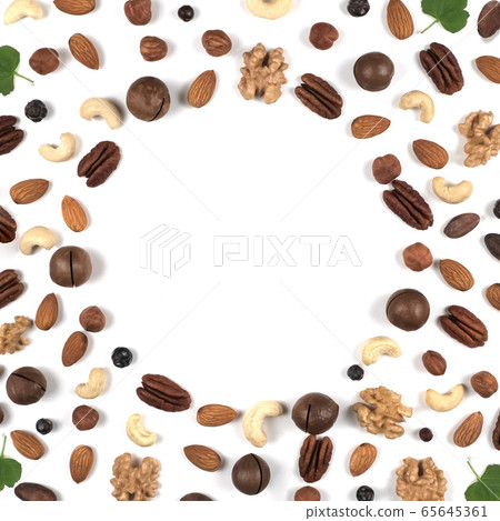 A pattern of nuts on a white background, decorated with green leaves. A pattern of nuts on a white background, decorated with green leaves. 65645361