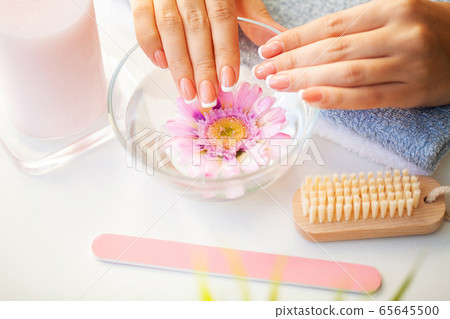Nails care. Beautiful woman's nails with french manicure, in beauty studio 65645500