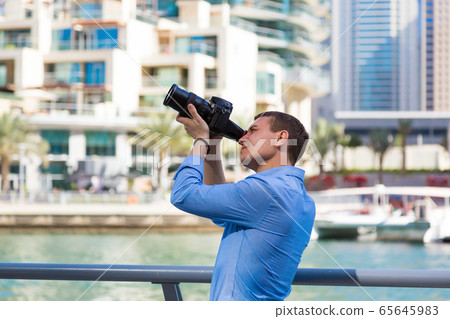 A photographer with a big camera in Dubai. 65645983