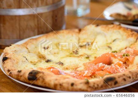 Homemade pizza with capers on a wood table Homemade pizza with capers on a wood table 65646856