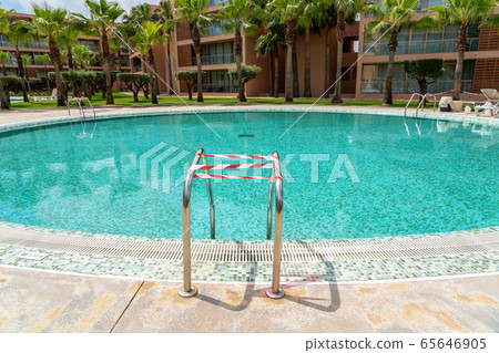 The pool during the coronavirus, located on the territory of the hotel, wrapped in a tape prohibiting entry into it. The pool during the coronavirus, located on the territory of the hotel, wrapped in a tape prohibiting entry into it. 65646905