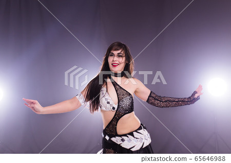 Young woman dancing in Tribal Fusion style. Belly dance on the stage. Young woman dancing in Tribal Fusion style. Belly dance on the stage. 65646988