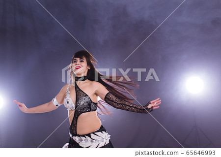 Spirituality dance. Beautiful sexy woman with luxury glossy eastern make-up dancing tribal fusion. Belly dance. Spirituality dance. Beautiful sexy woman with luxury glossy eastern make-up dancing tribal fusion. Belly dance. 65646993