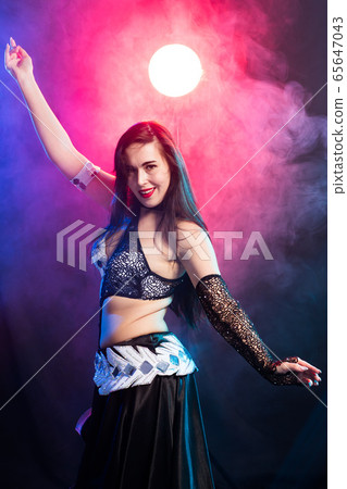 Young woman dancing in Tribal Fusion style. Belly dance on the stage. Young woman dancing in Tribal Fusion style. Belly dance on the stage. 65647043