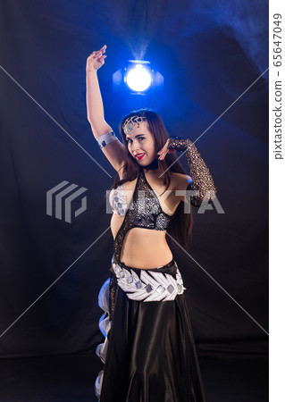 Spirituality dance. Beautiful sexy woman with luxury glossy eastern make-up dancing tribal fusion. Belly dance. Spirituality dance. Beautiful sexy woman with luxury glossy eastern make-up dancing tribal fusion. Belly dance. 65647049