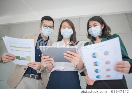 Business employees wearing mask during work in office 65647142