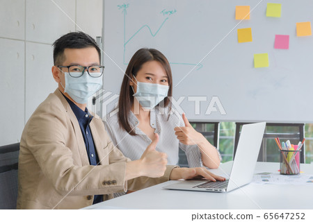 Business employees wearing mask during work in office to keep hygiene follow company policy 65647252