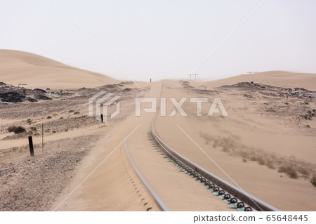 Abandoned and forgotten railway being taken over by encroaching sandstorm, Kolmanskop ghost town, Namib Desert. Africa 65648445