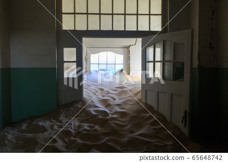Abandoned and forgotten building and room left by people and being taken over by encroaching sandstorm, Kolmanskop ghost town, Namib Desert 65648742