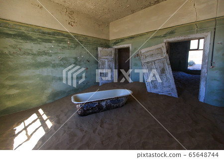 Abandoned and forgotten building and room left by people and being taken over by encroaching sandstorm, Kolmanskop ghost town, Namib Desert Abandoned and forgotten building and room left by people and being taken over by encroaching sandstorm, Kolmanskop ghost town, Namib Desert 65648744