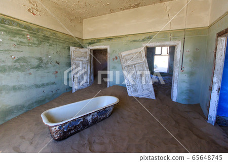 Abandoned and forgotten building and room left by people and being taken over by encroaching sandstorm, Kolmanskop ghost town, Namib Desert 65648745