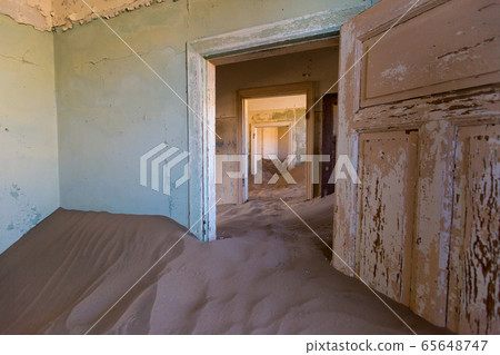 Abandoned and forgotten building and room left by people and being taken over by encroaching sandstorm, Kolmanskop ghost town, Namib Desert 65648747