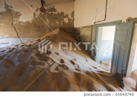 Abandoned and forgotten building and room left by people and being taken over by encroaching sandstorm, Kolmanskop ghost town, Namib Desert 65648749