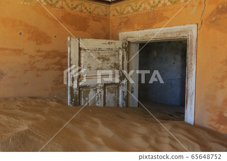 Abandoned and forgotten building and room left by people and being taken over by encroaching sandstorm, Kolmanskop ghost town, Namib Desert 65648752