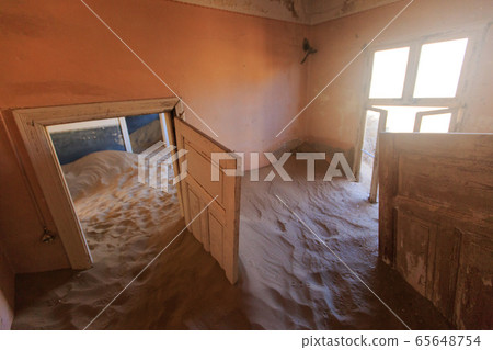 Abandoned and forgotten building and room left by people and being taken over by encroaching sandstorm, Kolmanskop ghost town, Namib Desert 65648754