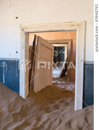 Abandoned and forgotten building and room left by people and being taken over by encroaching sandstorm, Kolmanskop ghost town, Namib Desert 65648763