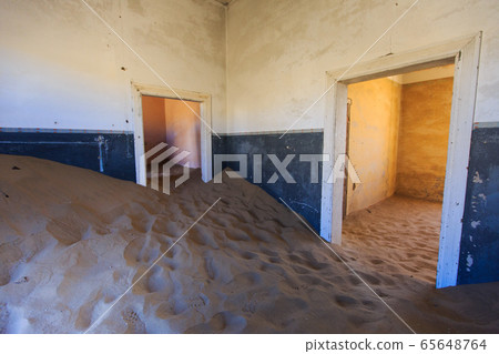 Abandoned and forgotten building and room left by people and being taken over by encroaching sandstorm, Kolmanskop ghost town, Namib Desert 65648764