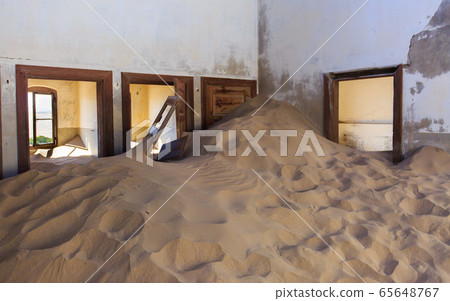 Abandoned and forgotten building and room left by people and being taken over by encroaching sandstorm, Kolmanskop ghost town, Namib Desert 65648767