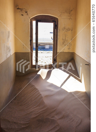 Abandoned and forgotten building and room left by people and being taken over by encroaching sandstorm, Kolmanskop ghost town, Namib Desert 65648770
