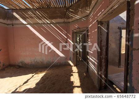 Abandoned and forgotten building and room left by people and being taken over by encroaching sandstorm, Kolmanskop ghost town, Namib Desert Abandoned and forgotten building and room left by people and being taken over by encroaching sandstorm, Kolmanskop ghost town, Namib Desert 65648772