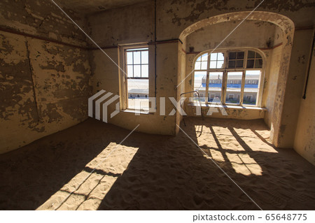 Abandoned and forgotten building and room left by people and being taken over by encroaching sandstorm, Kolmanskop ghost town, Namib Desert 65648775