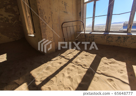 Abandoned and forgotten building and room left by people and being taken over by encroaching sandstorm, Kolmanskop ghost town, Namib Desert 65648777