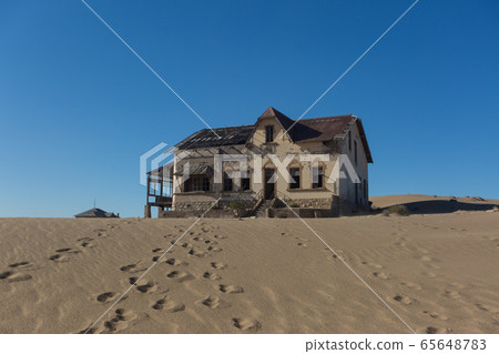 Abandoned and forgotten building and room left by people and being taken over by encroaching sandstorm, Kolmanskop ghost town, Namib Desert 65648783
