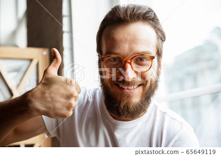 Caucasian musician greeting audience before online concert at home isolated and quarantined, cheerful, smiling Caucasian musician greeting audience before online concert at home isolated and quarantined, cheerful, smiling 65649119