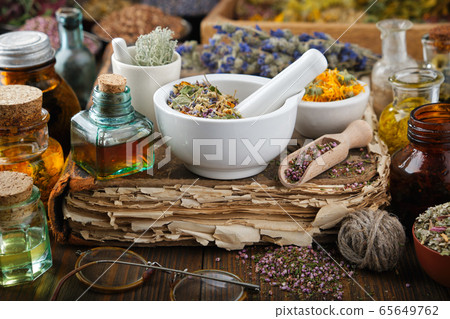 Bottles of infusion or oil, medicinal herbs. 65649762