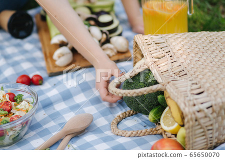 Close-up of waman take vegetables from picnic basket Close-up of waman take vegetables from picnic basket 65650070