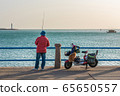 Fisherman fishing along the waterfront 65650557