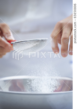 Image of pastry chef that sifts flour Image of pastry chef that sifts flour 65650806
