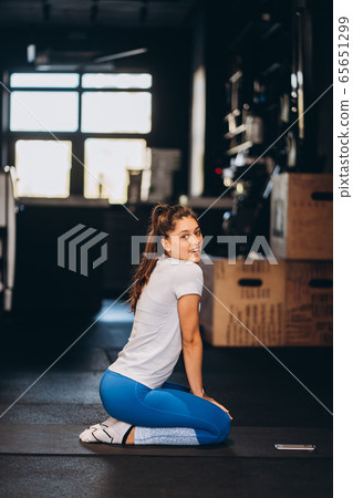 Young yoga woman kneeling on the floor. Young yoga woman kneeling on the floor. 65651299