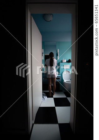 Back view of pretty young woman in front of mirror, selective focus. Back view of pretty young woman in front of mirror, selective focus. 65651341