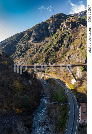 The mountain river along the Road, Aerial panoramic drone view of a scenic highway by the beautiful Landscape covered in clouds and fog, bridge and viaduct, The mountain river along the road, 65651804