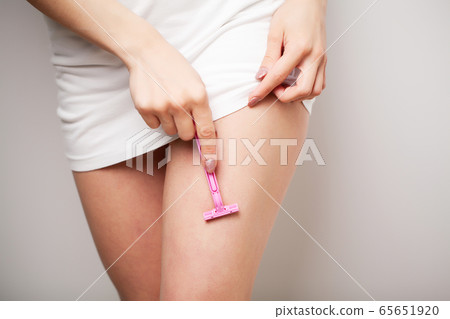 Woman doing hair removal at home in bathroom 65651920