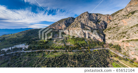 Aerial view of antique Theatre and Apollo Temple in Delphi, Greece at sunrise, famous archaeological site in Greece, Morning fog over mountains, hoarfrost on roofs 65652104