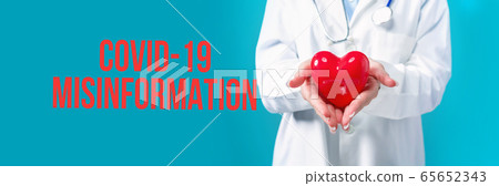Covid-19 Misinformation theme with a doctor holding a heart 65652343