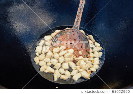 Roasting of mutton fat to a condition of crackers, some stage of preparation of a national Uzbek dish pilaf, shovel for food, cauldron, fire, firewood, outdoor 65652960