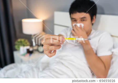 sick man using thermometer and showing high sick man using thermometer and showing high 65655016
