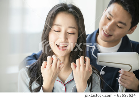 Couple, hair dryer, pajamas Couple, hair dryer, pajamas 65655624