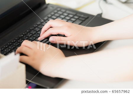 A woman working with a laptop A woman working with a laptop 65657962